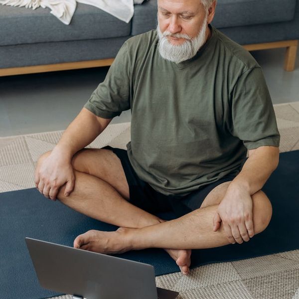 Group of diverse people sitting in a comfortable cross-legged yoga pose.