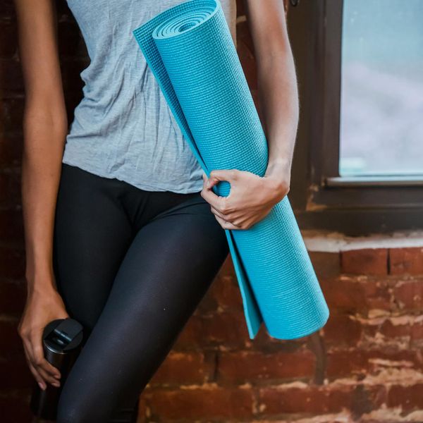 Neatly rolled yoga mat, a water bottle, and a small towel ready for a class.